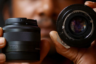 Cropped image of man holding lenses