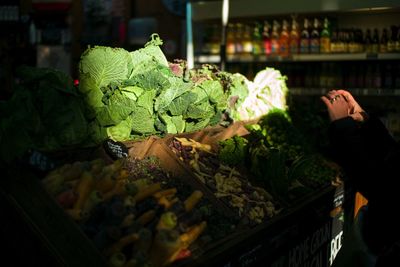 Young woman with vegetables for sale in market