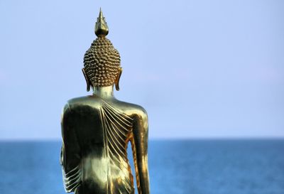Statue of buddha against sea