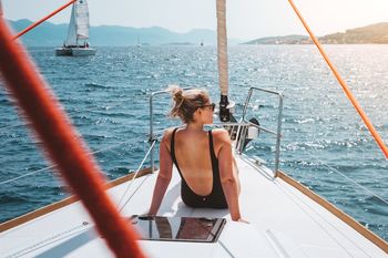 Rear view of woman traveling in yacht sailing on sea