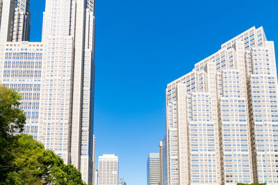 Low angle view of modern buildings against clear blue sky