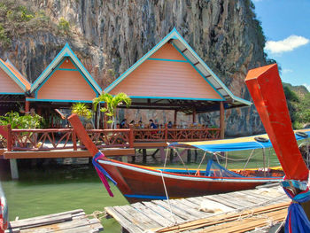 Boats moored by lake against sky