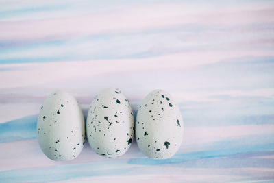 Close-up of quail eggs against colored background