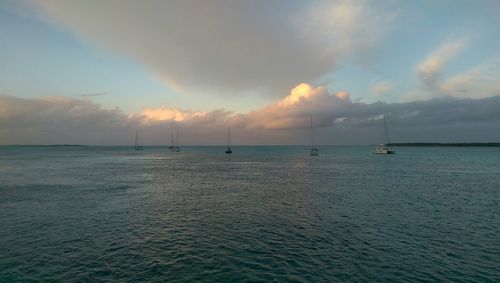 Boat sailing in sea at sunset