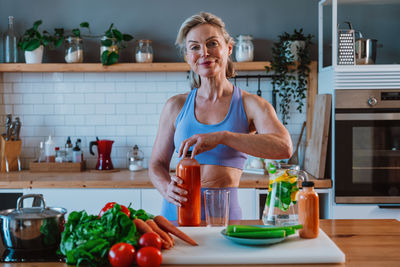 Portrait of young woman preparing food at home