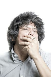 Woman smoking cigarette against white background