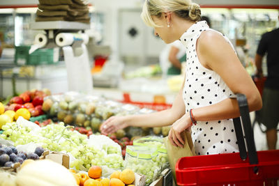 Midsection of woman with ice cream at market