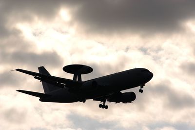 Silhouette of military airplane e-767 awacs in evening sky