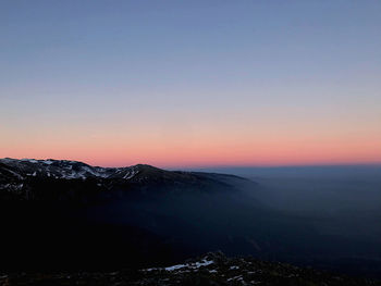 Scenic view of mountains against clear sky during sunset