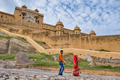 Full length of friends standing at historical building