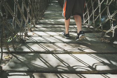 Low section of person walking on footbridge