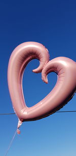 Low angle view of balloons against blue sky