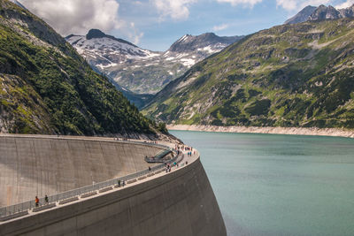 Scenic view of dam and mountains against sky