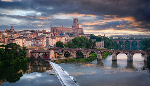 Bridge over river against sky during sunset