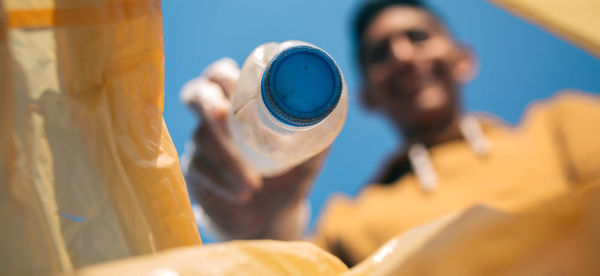 Close-up of man holding plastic bottle