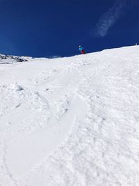 Man skiing on snowy field against sky