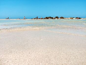 Scenic view of beach against clear blue sky
