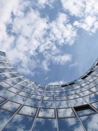 Low angle view of modern building against cloudy sky