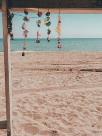 Clothes hanging on beach against sky