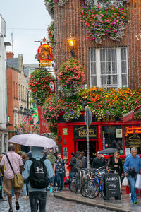 Rear view of people walking on street against buildings