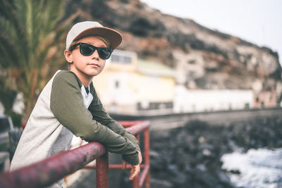 Portrait of young man wearing sunglasses sitting outdoors