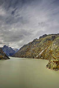 Scenic view of lake by mountains against sky