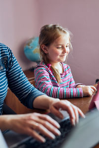 Smiling girl sitting with mother at home