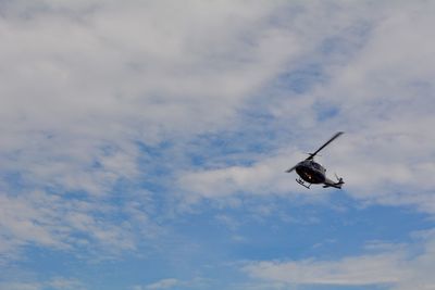 Low angle view of helicopter flying in sky