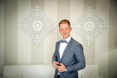 Portrait of smiling businessman standing at home