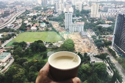 High angle view of coffee cup and cityscape