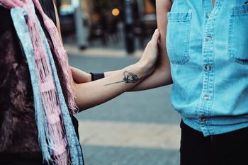 CLOSE-UP OF HANDS AGAINST BLUE SKY