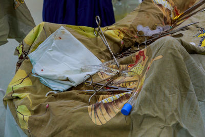 High angle view of medical equipment on patient lying under blanket in hospital