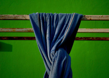 Close-up of blue towel against green wall