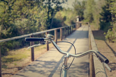 Close-up of bicycle on railing against trees