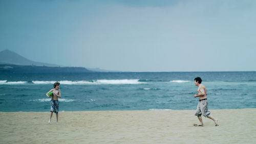 Rear view of man standing on beach