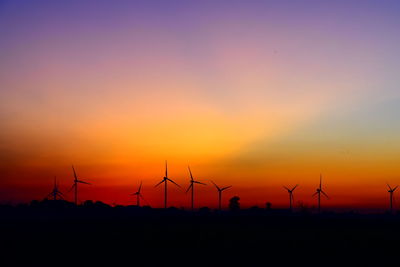 Silhouette of wind turbines at sunset