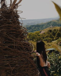 Side view of woman standing against landscape and sky