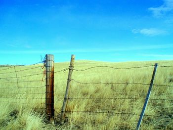 Wooden fence on field against sky