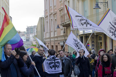 People on street against buildings in city