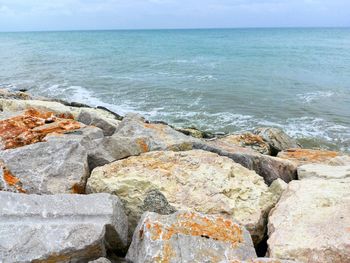 Rocks on sea shore against sky