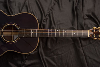 High angle view of guitar on bed