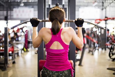 Rear view of woman exercising at gym