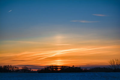 Scenic view of winter landscape against sky during sunset