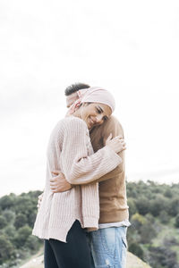 Smiling girlfriend embracing boyfriend