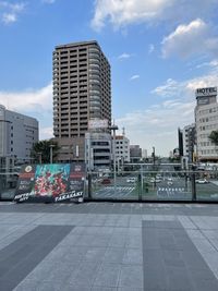 Buildings in city against cloudy sky