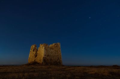 Low angle view of castle on field against sky at night