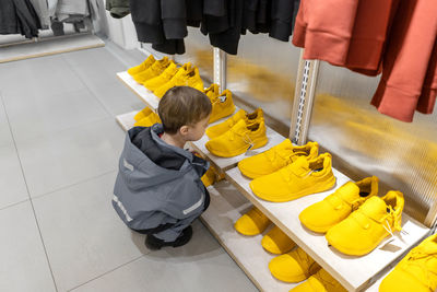 High angle view of boy sitting on tiled floor