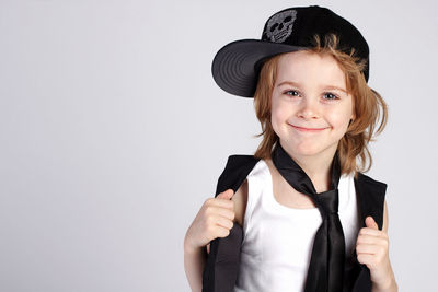 Portrait of smiling girl standing against white background