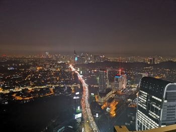 High angle view of illuminated buildings against sky at night