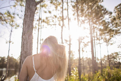 Woman looking at trees against sky